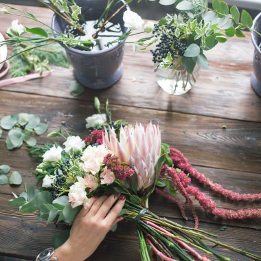 İş yerinde çiçekçi: genç ve güzel sarışın kadın moda modern buket farklı çiçek yapma