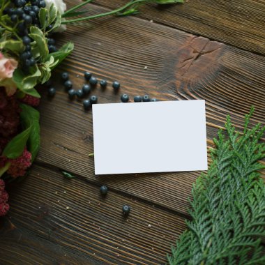 Florist workplace: visit card and flowers and accessories on a vintage wooden table. soft focus