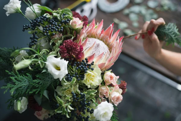 Florist workplace: flowers and accessories on a vintage wooden table. soft focus