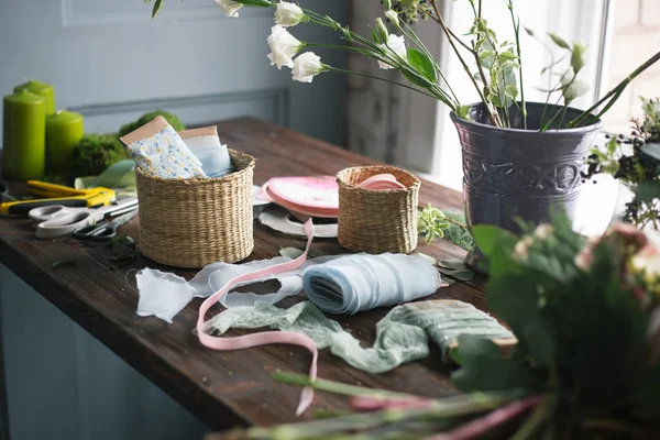 Florist workplace: flowers and accessories on a vintage wooden table. soft focus — Stock Photo, Image