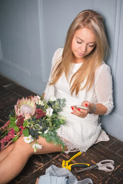 Fiorista al lavoro: bella giovane donna bionda che fa moda bouquet moderno di fiori diversi — Foto Stock