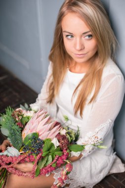 İş yerinde çiçekçi: genç ve güzel sarışın kadın moda modern buket farklı çiçek yapma