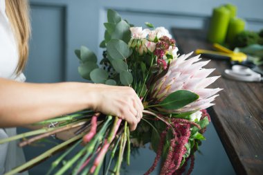 İş yerinde çiçekçi: genç ve güzel sarışın kadın moda modern buket farklı çiçek yapma