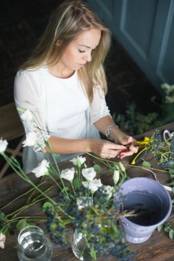 İş yerinde çiçekçi: genç ve güzel sarışın kadın moda modern buket farklı çiçek yapma