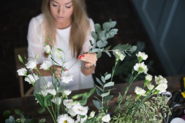 İş yerinde çiçekçi: genç ve güzel sarışın kadın moda modern buket farklı çiçek yapma