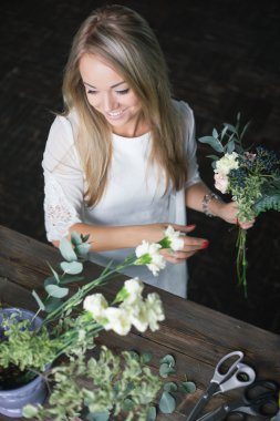 İş yerinde çiçekçi: genç ve güzel sarışın kadın moda modern buket farklı çiçek yapma