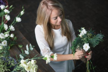 İş yerinde çiçekçi: genç ve güzel sarışın kadın moda modern buket farklı çiçek yapma