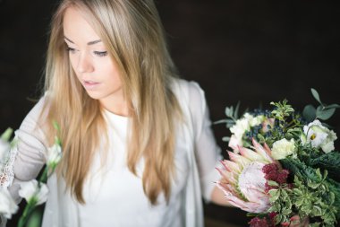 İş yerinde çiçekçi: genç ve güzel sarışın kadın moda modern buket farklı çiçek yapma