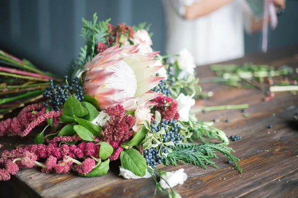 Florist workplace: flowers and accessories on a vintage wooden table. soft focus