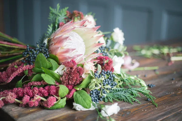 Floristik-Arbeitsplatz: Blumen und Accessoires auf einem Holztisch. Weicher Fokus — Stockfoto