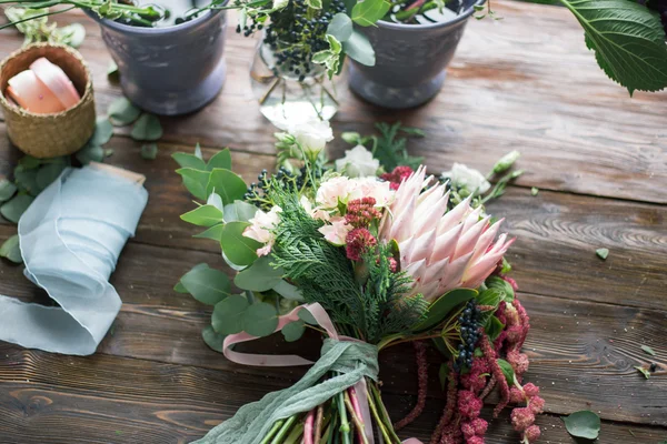 플로리스트 직장: 꽃과 빈티지 나무 테이블에 액세서리. 소프트 포커스 — 스톡 사진
