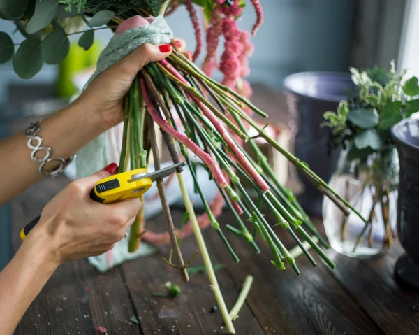 Florista en el trabajo: mujer rubia bastante joven haciendo ramo moderno de moda de diferentes flores — Foto de Stock