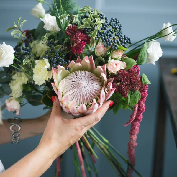 Bloemist op het werk: mooie jonge blonde vrouw mode moderne boeket van verschillende bloemen maken — Stockfoto