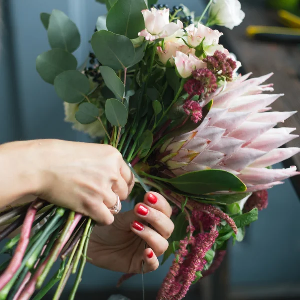 在工作的花店: 年轻漂亮的金发碧眼女人做时尚现代的不同的花束 — 图库照片