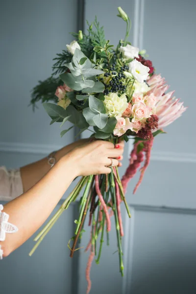 Florista no trabalho: mulher loira muito jovem fazendo moda buquê moderno de flores diferentes — Fotografia de Stock