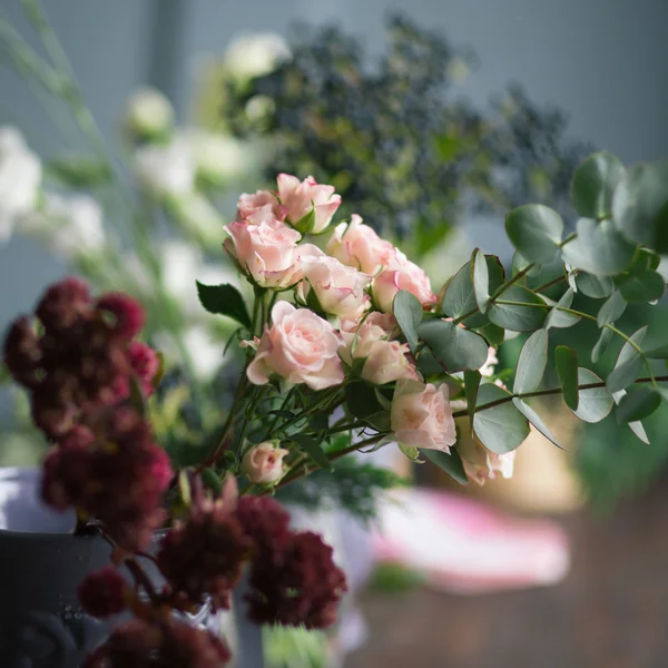 Floristería: flores y accesorios en una mesa de madera vintage. enfoque suave — Foto de Stock