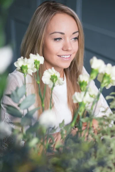 Florista en el trabajo: mujer rubia bastante joven haciendo ramo moderno de moda de diferentes flores — Foto de Stock