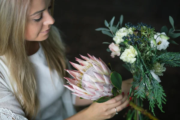 Bloemist op het werk: mooie jonge blonde vrouw mode moderne boeket van verschillende bloemen maken — Stockfoto