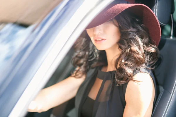 Close-up retrato de linda jovem morena dirigindo um carro caro — Fotografia de Stock