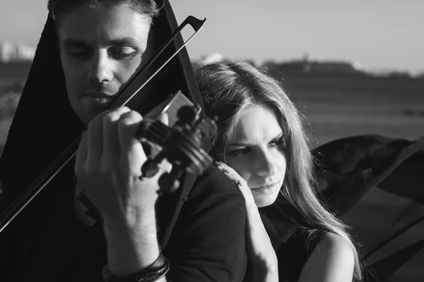 Beautiful couple violinist and young woman together near sea bay