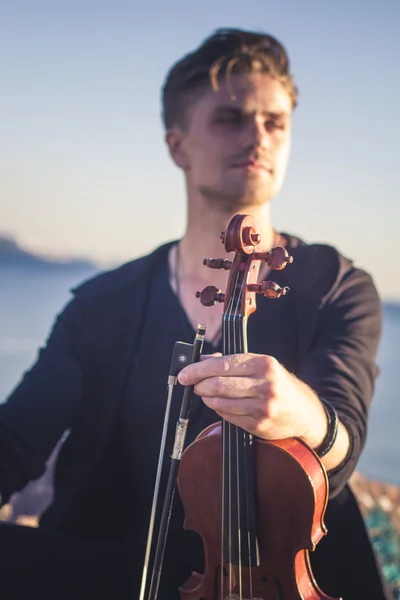 Guapo joven violinista sobre fondo pintoresco — Foto de Stock