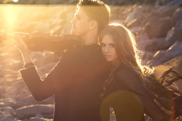 Vackra par violinist och ung kvinna tillsammans nära havet bay — Stockfoto