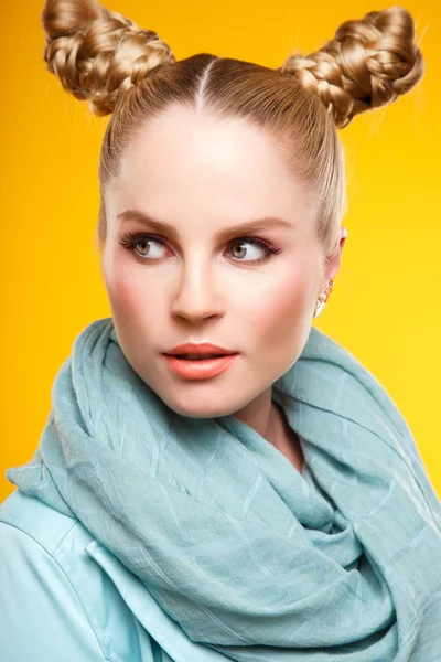 Belle femme blonde glamour avec maquillage de mode et coiffure. portrait rapproché sur fond jaune — Photo