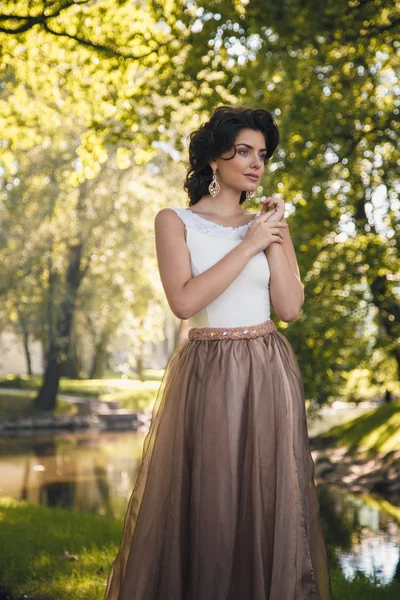 Portré, szép elegáns menyasszony gyönyörű bézs ruha sétál a parkban — Stock Fotó