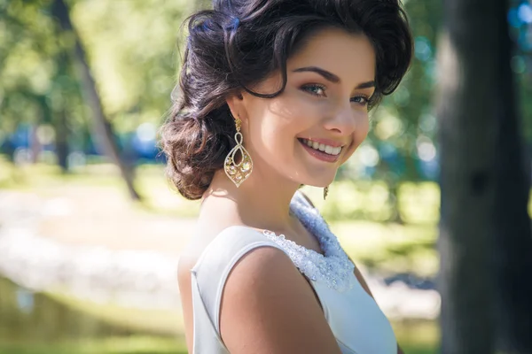 Retrato de bela noiva elegante em lindo vestido bege caminha em um parque — Fotografia de Stock