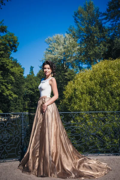 Portré, szép elegáns menyasszony gyönyörű bézs ruha sétál a parkban — Stock Fotó
