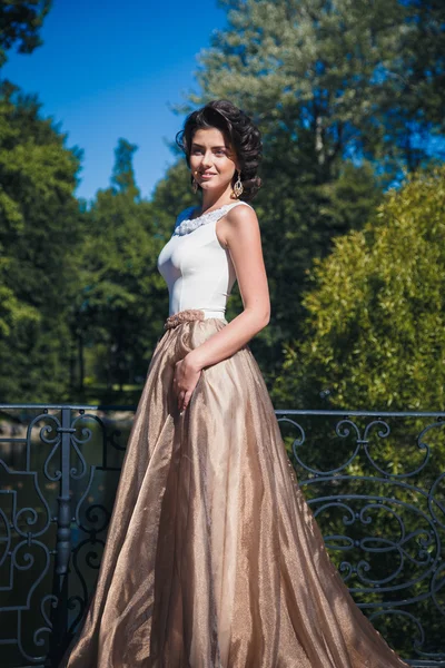 Retrato de hermosa novia elegante en vestido beige magnífico camina en un parque — Foto de Stock