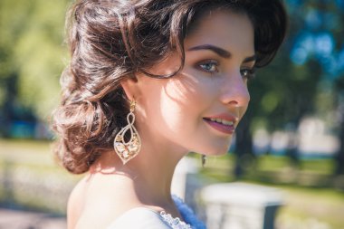 Güzel bej elbise güzel zarif gelin portresi bir parkta yürüyor