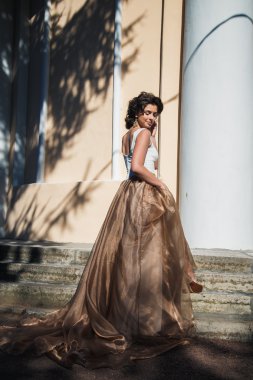 Güzel bej elbise güzel zarif gelin portresi bir parkta yürüyor