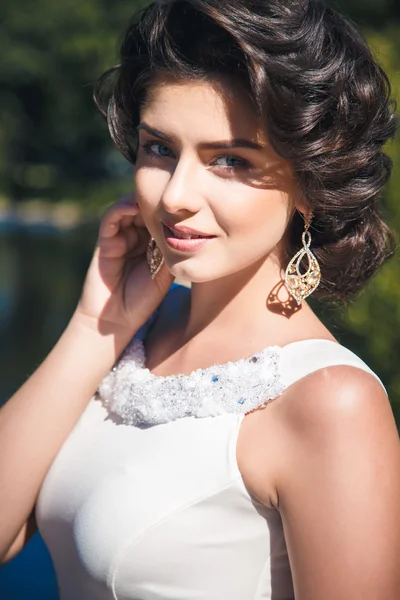 Retrato de bela noiva elegante em lindo vestido bege caminha em um parque — Fotografia de Stock