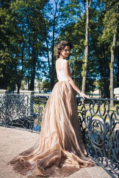 Portrait of beautiful elegant bride in gorgeous beige dress walks in a park — Stock Photo, Image