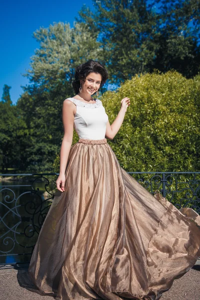 Retrato de bela noiva elegante em lindo vestido bege caminha em um parque — Fotografia de Stock