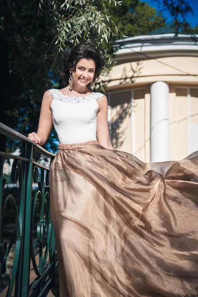 Portrait of beautiful elegant bride in gorgeous beige dress walks in a park — Stock Photo, Image