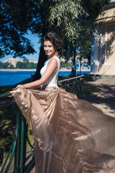 Portrait of beautiful elegant bride in gorgeous beige dress walks in a park — Stock Photo, Image