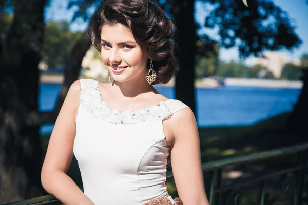 Ritratto di bella sposa elegante in splendido abito beige passeggiate in un parco — Foto Stock