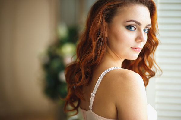 Closeup portrait of redhead young woman in gorgeous lingerie in luxury interior