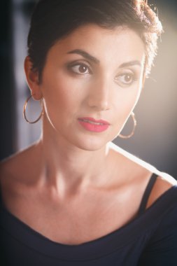 Close-up portrait of gorgeous woman with short black hair and long earrings