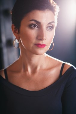 Close-up portrait of gorgeous woman with short black hair and long earrings