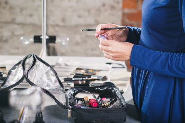 Makeup artist and her workplace. Woman and cosmetics.