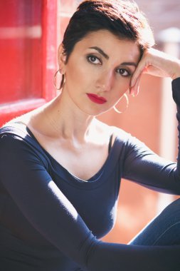 Close-up portrait of gorgeous woman with short black hair and long earrings