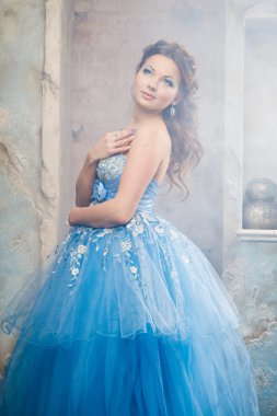 Muhteşem mavi uzun elbiseli güzel genç kadın mükemmel makyajlı ve saç stili olan Cinderella gibi.