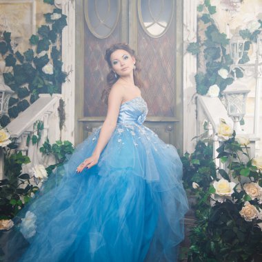 Muhteşem mavi uzun elbiseli güzel genç kadın mükemmel makyajlı ve saç stili olan Cinderella gibi.