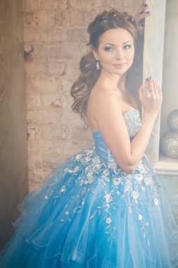 Muhteşem mavi uzun elbiseli güzel genç kadın mükemmel makyajlı ve saç stili olan Cinderella gibi.