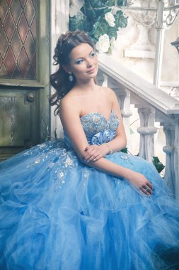 Muhteşem mavi uzun elbiseli güzel genç kadın mükemmel makyajlı ve saç stili olan Cinderella gibi.