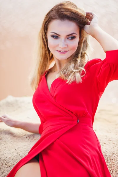 Preciosa mujer joven cabeza roja en vestido largo rojo sobre un fondo de un lago. Sandy Canyon. Estilo de moda —  Fotos de Stock