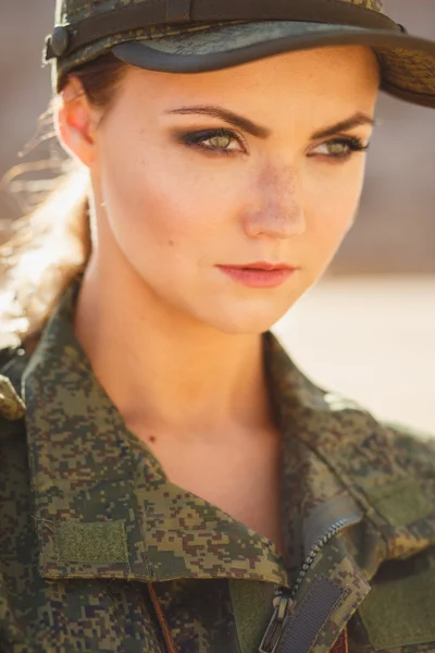 Чудова молода жінка в військовому костюмі на фоні десерту — стокове фото
